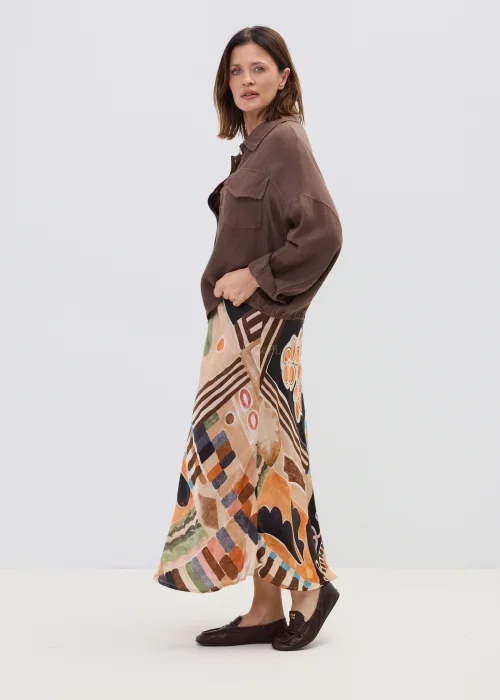 Brązowa lniana koszula oversize z kieszeniami na piersi i guzikami, lekka i naturalna, stylizowana z wzorzystą spódnicą w casualowym looku.