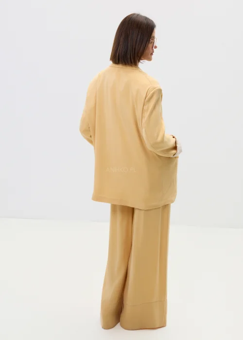 Marynarka damska w masełkowym odcieniu, o luźnym kroju z klapami, zapinana na guziki, z kieszeniami – elegancki styl w nowoczesnym, lekkim wydaniu.