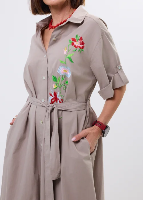 Sukienka koszulowa midi w kolorze taupe z kolorowym haftem kwiatowym i wiązaniem w talii. Model z kołnierzykiem i podwijanymi rękawami wyróżnia się eleganckim, kobiecym fasonem.
