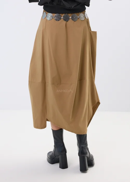 Spódnica midi w karmelowym odcieniu o asymetrycznym, lekko oversize’owym fasonie. Model z efektownymi przeszyciami i dużą kieszenią po boku nadaje stylizacji nowoczesnego charakteru i swobodnego ruchu.