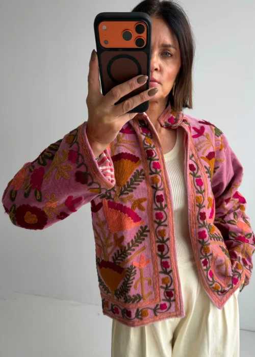 Różowy żakiet boho zdobiony bogatymi haftami kwiatowymi w kontrastowych kolorach. Oryginalny model o artystycznym i folkowym charakterze.