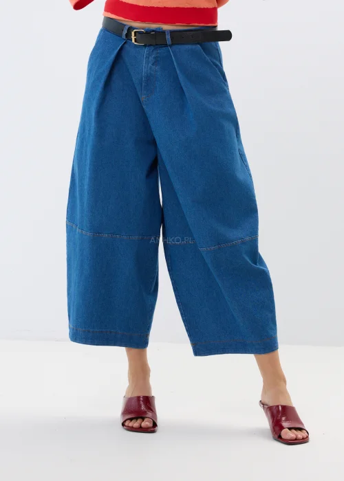 Granatowe jeansy damskie culotte z szerokimi nogawkami i wysokim stanem. Luźny fason w miejskiej stylizacji z bordowymi klapkami.