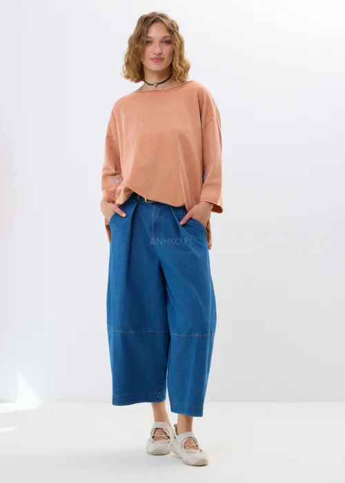 Oversize’owa bluzka w morelowym odcieniu z szerokimi rękawami i haftowanym kwiatem. Swobodny fason zapewnia wygodę i casualowy styl.