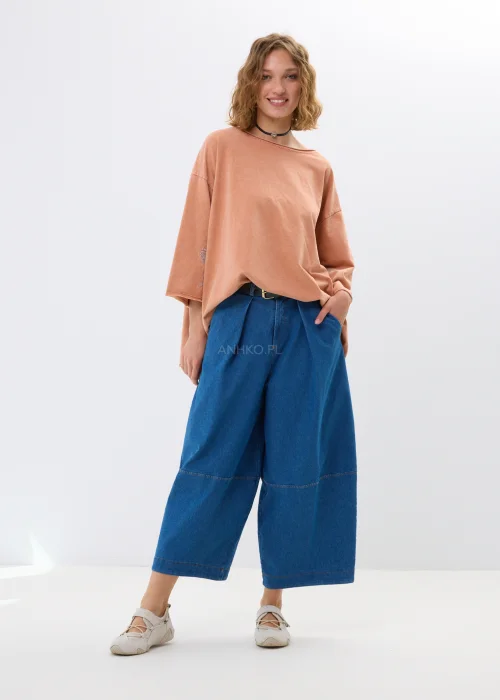 Oversize’owa bluzka w morelowym odcieniu z szerokimi rękawami i haftowanym kwiatem. Swobodny fason zapewnia wygodę i casualowy styl.