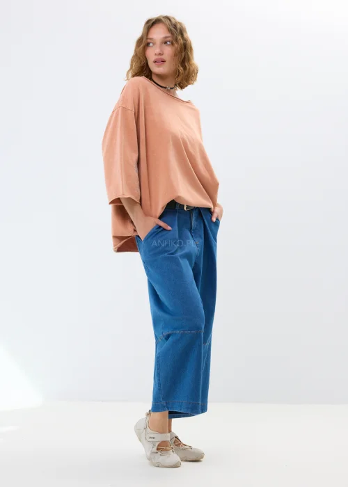 Oversize’owa bluzka w morelowym odcieniu z szerokimi rękawami i haftowanym kwiatem. Swobodny fason zapewnia wygodę i casualowy styl.