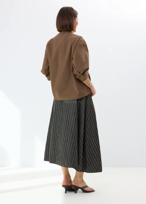 Brązowa bluzka damska z kopertowym przodem i efektownym wiązaniem. Elegancki model z bufiastymi rękawami i luźnym fasonem podkreśla nowoczesny charakter stylizacji.