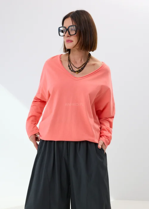 Oversize’owa bluzka damska w jasnoróżowym odcieniu z dekoltem V-neck i luźnym fasonem. Miękko układa się na sylwetce, tworząc wygodną stylizację z szerokimi spodniami lub spódnicą maxi w casualowym stylu.