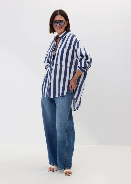 Lniana koszula damska w granatowo-białe paski o luźnym fasonie z naturalnej tkaniny w casualowej stylizacji.