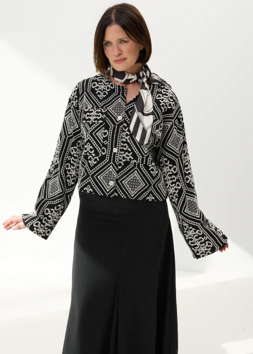 Czarno-biała koszula damska z efektownym haftowanym wzorem inspirowanym stylem boho i etnicznymi ornamentami. Luźny fason z szerokimi rękawami oraz kontrastowe zdobienia nadają modelowi wyjątkowego charakteru.