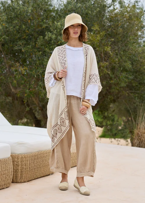 Kimono boho ecru z geometrycznym wzorem w odcieniach beżu. Długi, luźny fason z lekkiej dzianiny tworzy efektowną warstwową stylizację i doskonale komponuje się z lnianymi ubraniami.