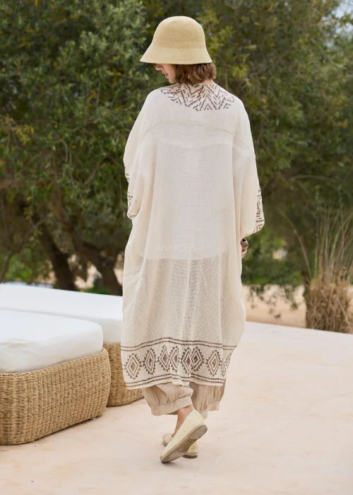 Kimono boho ecru z geometrycznym wzorem w odcieniach beżu. Długi, luźny fason z lekkiej dzianiny tworzy efektowną warstwową stylizację i doskonale komponuje się z lnianymi ubraniami.