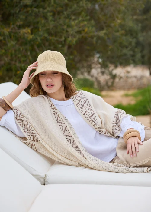 Kimono boho ecru z geometrycznym wzorem w odcieniach beżu. Długi, luźny fason z lekkiej dzianiny tworzy efektowną warstwową stylizację i doskonale komponuje się z lnianymi ubraniami.
