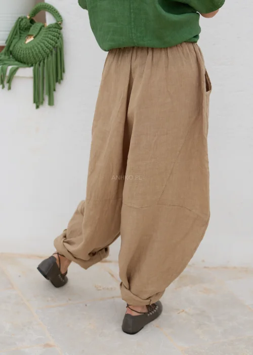Lniane spodnie damskie camel o luźnym, balonowym fasonie z elastyczną talią i kieszeniami. Komfortowy model w naturalnym stylu casual.