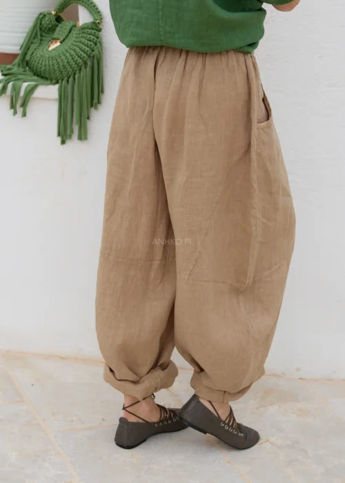 Lniane spodnie damskie camel o luźnym, balonowym fasonie z elastyczną talią i kieszeniami. Komfortowy model w naturalnym stylu casual.