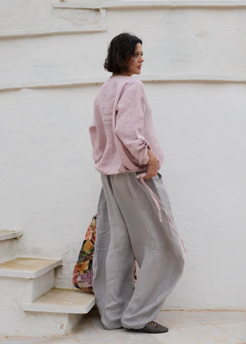 Różowa bluzka lniana z długim rękawem i elastycznym wykończeniem dołu. Luźny fason doskonale komponuje się z jasnymi lnianymi spodniami w naturalnej stylizacji.