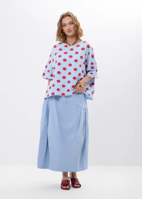 Niebieska bluzka oversize w czerwone grochy z krótkim rękawem i luźnym fasonem. Lekki materiał pięknie układa się na sylwetce, tworząc kobiecą stylizację w retro klimacie z wyrazistym printem.