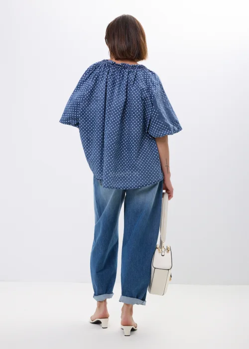 Bluzka damska oversize w kolorze granatowym w drobne groszki. Zwiewny model z szerokimi rękawami i wiązaniem przy dekolcie w stylu boho świetnie komponuje się z jeansami oraz casualowymi stylizacjami.