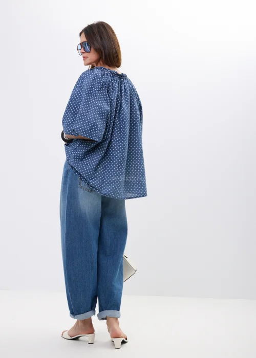Bluzka damska oversize w kolorze granatowym w drobne groszki. Zwiewny model z szerokimi rękawami i wiązaniem przy dekolcie w stylu boho świetnie komponuje się z jeansami oraz casualowymi stylizacjami.