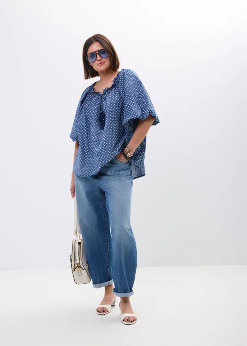Bluzka damska oversize w kolorze granatowym w drobne groszki. Zwiewny model z szerokimi rękawami i wiązaniem przy dekolcie w stylu boho świetnie komponuje się z jeansami oraz casualowymi stylizacjami.