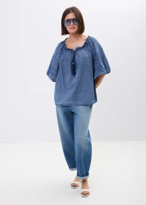 Bluzka damska oversize w kolorze granatowym w drobne groszki. Zwiewny model z szerokimi rękawami i wiązaniem przy dekolcie w stylu boho świetnie komponuje się z jeansami oraz casualowymi stylizacjami.