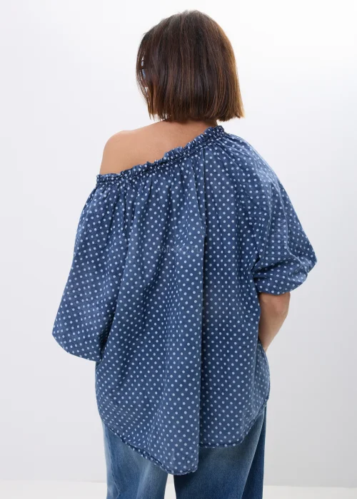 Bluzka damska oversize w kolorze granatowym w drobne groszki. Zwiewny model z szerokimi rękawami i wiązaniem przy dekolcie w stylu boho świetnie komponuje się z jeansami oraz casualowymi stylizacjami.