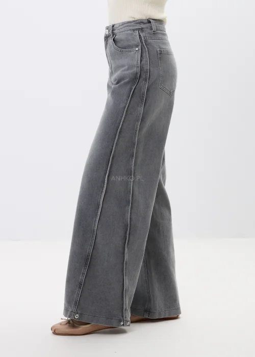 Jeansy damskie wide leg w szarym odcieniu z modnym spranym efektem. Model z wysokim stanem oraz zatrzaskami na dole nogawek pozwala regulować fason i nadaje całości nowoczesnego charakteru.