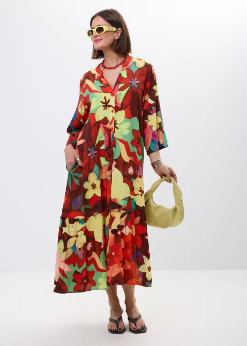 Długa sukienka maxi w kolorowy kwiatowy print z falbaną i rękawem 3/4. Zwiewny model z guziczkami i luźnym fasonem idealny do letnich stylizacji boho oraz casual chic.