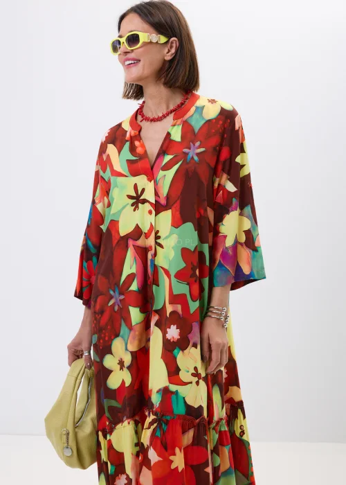 Długa sukienka maxi w kolorowy kwiatowy print z falbaną i rękawem 3/4. Zwiewny model z guziczkami i luźnym fasonem idealny do letnich stylizacji boho oraz casual chic.