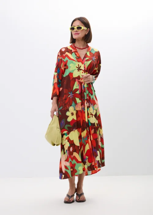 Długa sukienka maxi w kolorowy kwiatowy print z falbaną i rękawem 3/4. Zwiewny model z guziczkami i luźnym fasonem idealny do letnich stylizacji boho oraz casual chic.