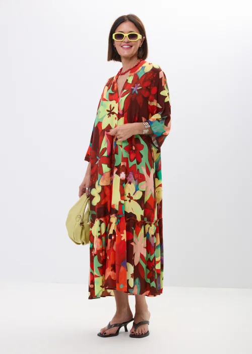 Długa sukienka maxi w kolorowy kwiatowy print z falbaną i rękawem 3/4. Zwiewny model z guziczkami i luźnym fasonem idealny do letnich stylizacji boho oraz casual chic.