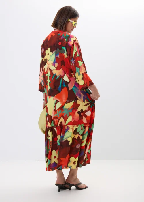 Długa sukienka maxi w kolorowy kwiatowy print z falbaną i rękawem 3/4. Zwiewny model z guziczkami i luźnym fasonem idealny do letnich stylizacji boho oraz casual chic.
