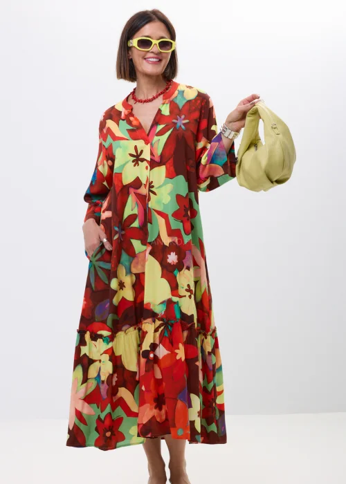 Długa sukienka maxi w kolorowy kwiatowy print z falbaną i rękawem 3/4. Zwiewny model z guziczkami i luźnym fasonem idealny do letnich stylizacji boho oraz casual chic.