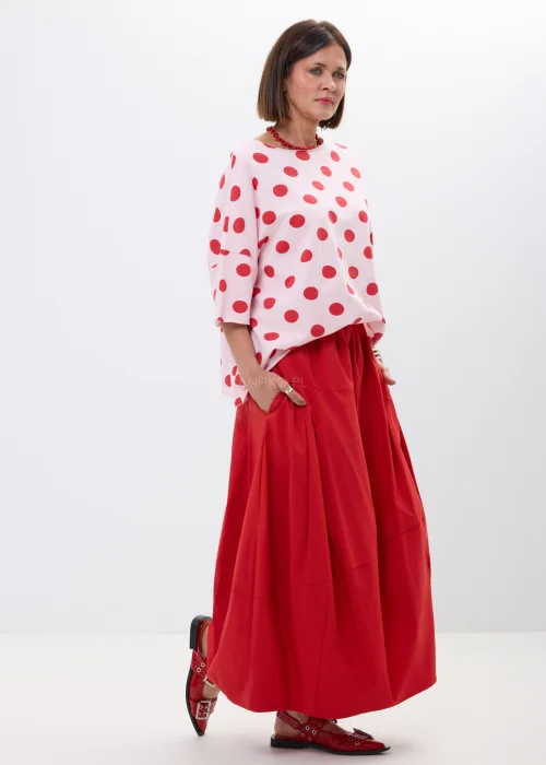 Różowa bluzka oversize w czerwone grochy z szerokim rękawem i minimalistycznym dekoltem. Kobiecy model idealny do  stylizacji w klimacie retro chic i casual fashion.