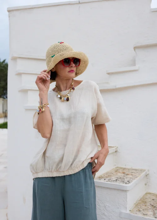 Bransoletka charms w złotym kolorze z dekoracyjnymi zawieszkami i czerwonym kamieniem. Efektowna biżuteria damska z motywem serca, idealna do casualowych i boho stylizacji.