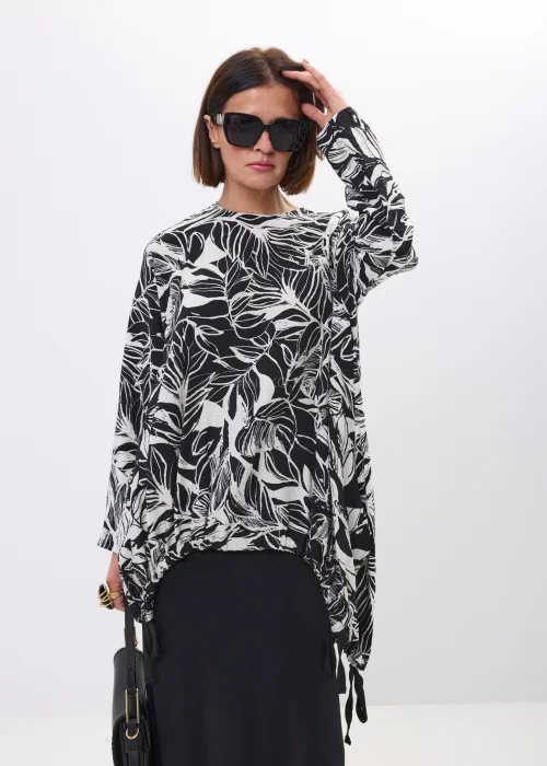 Bluzka-tunika oversize w czarno-biały print liści. Asymetryczny fason z wiązaniami po bokach nadaje stylizacji nowoczesny i artystyczny charakter.