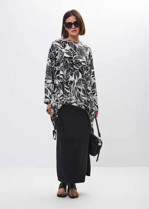 Bluzka-tunika oversize w czarno-biały print liści. Asymetryczny fason z wiązaniami po bokach nadaje stylizacji nowoczesny i artystyczny charakter.