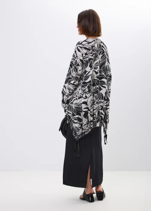 Bluzka-tunika oversize w czarno-biały print liści. Asymetryczny fason z wiązaniami po bokach nadaje stylizacji nowoczesny i artystyczny charakter.