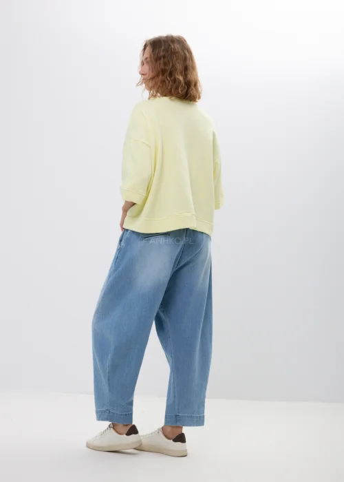 Spodnie jeansowe typu baggy w jasnoniebieskim odcieniu z elastyczną talią i wiązaniem. Luźny, komfortowy fason z kieszeniami doskonale wpisuje się w swobodne, codzienne stylizacje.