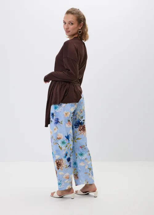 Brązowa bluzka z efektownym wiązaniem w talii i luźnym fasonem oversize. Model z długim rękawem oraz asymetrycznym drapowaniem podkreśla sylwetkę i tworzy elegancką, kobiecą stylizację.