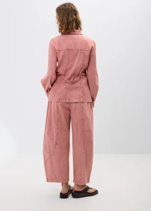 Różowa koszula jeansowa z długim rękawem, kołnierzykiem i zapięciem na napy. Model z kieszeniami na piersi i dopasowanym fasonem tworzy modną stylizację denim total look w kobiecym wydaniu.