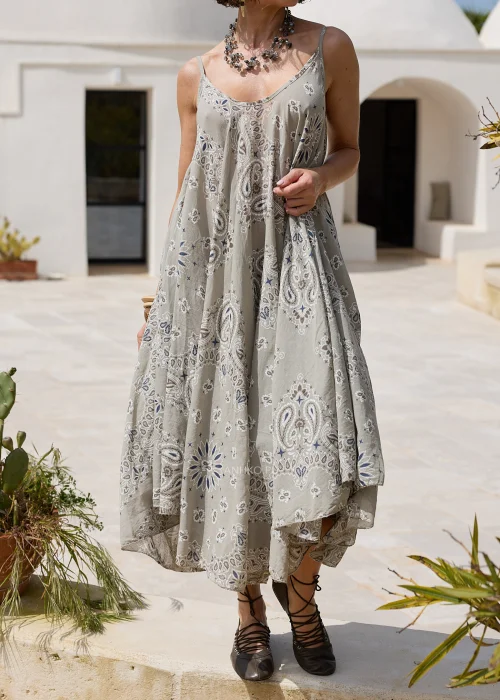 Sukienka w kolorze taupe z ozdobnym wzorem paisley w odcieniach beżu i błękitu. Zwiewny model o luźnym kroju z lnianą górą i rozkloszowanym dołem prezentowany w naturalnej stylizacji.