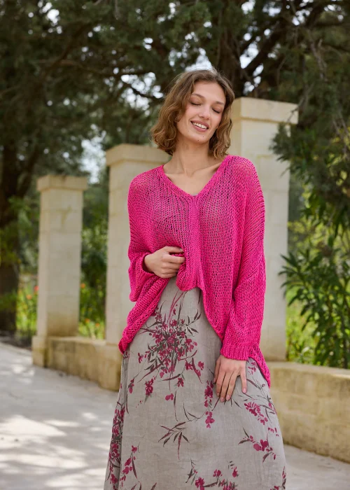 Sweter ażurowy damski w intensywnym kolorze magenta o luźnym fasonie oversize. Lekki splot i dekolt V nadają stylizacji nowoczesnego charakteru.