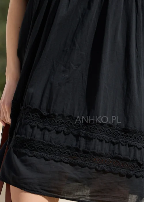 Czarna sukienka boho z haftowanymi detalami i koronkowymi wstawkami, o luźnym fasonie i bufiastych rękawach. Kobiecy model mini idealny do letnich stylizacji z plecioną torbą i dodatkami w naturalnym stylu.