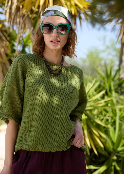 Oliwkowy ażurowy sweter damski oversize z krótkim rękawem i okrągłym dekoltem. Lekki, siateczkowy splot nadaje modelowi swobodny charakter i doskonale sprawdza się w casualowych, warstwowych stylizacjach.