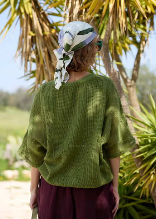 Oliwkowy ażurowy sweter damski oversize z krótkim rękawem i okrągłym dekoltem. Lekki, siateczkowy splot nadaje modelowi swobodny charakter i doskonale sprawdza się w casualowych, warstwowych stylizacjach.