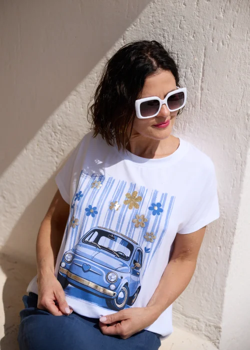Biały T-shirt damski z nadrukiem niebieskiego retro samochodu i dekoracyjnymi kwiatami 3D, zestawiony z granatową spódnicą. Casualowy model o luźnym kroju idealny do codziennych stylizacji w letnim, miejskim stylu.