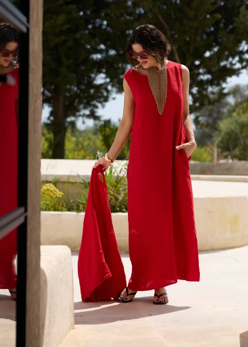 Czerwona lniana sukienka maxi bez rękawów z okrągłym dekoltem, luźnym fasonem i praktycznymi kieszeniami. Minimalistyczna stylizacja podkreśla elegancki, swobodny charakter modelu.