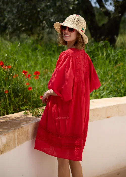 Czerwona sukienka boho o luźnym fasonie z ażurowymi wstawkami i szerokimi rękawami 3/4. Kobiecy model przed kolano, idealny na wakacyjne spacery, codzienne stylizacje i letni wypoczynek.