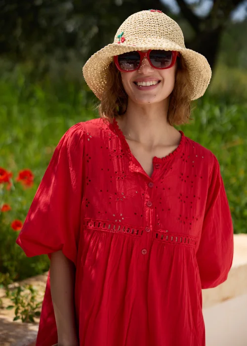 Czerwona sukienka boho o luźnym fasonie z ażurowymi wstawkami i szerokimi rękawami 3/4. Kobiecy model przed kolano, idealny na wakacyjne spacery, codzienne stylizacje i letni wypoczynek.