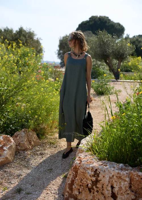 Oliwkowa lniana sukienka maxi na szerokich ramiączkach o luźnym, minimalistycznym kroju. Naturalna tkanina i swobodny fason tworzą ponadczasową stylizację w stylu boho i slow fashion.